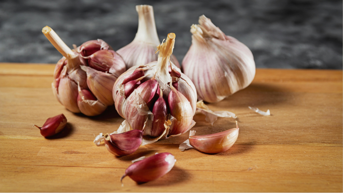A spoon of thick garlic sauce beside grilled chicken and rice