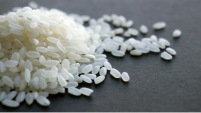 Bowl of basmati rice with separate grains served next to grilled chicken.