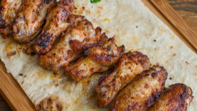 Lava charcoal chicken wings with golden blistered skin served with sauces