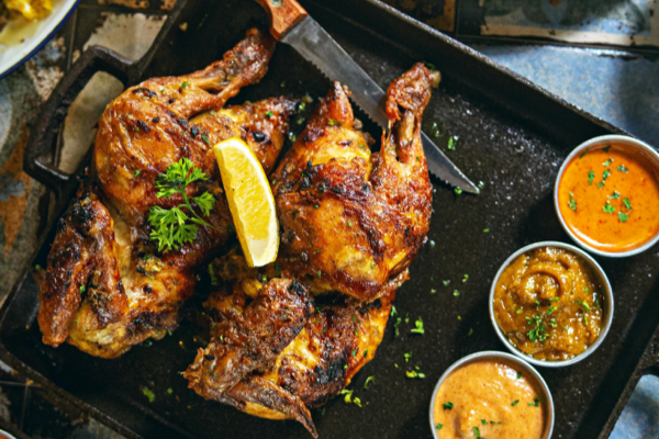 Close-up of rotisserie chicken skin crisping under gas heat