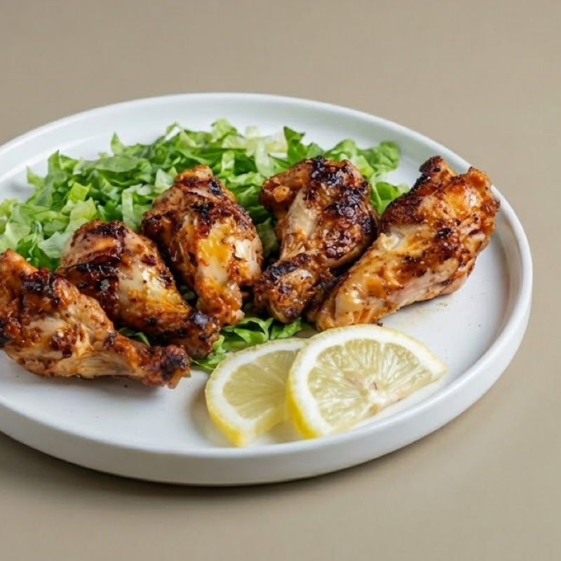 Five grilled chicken wings with charred edges and dip