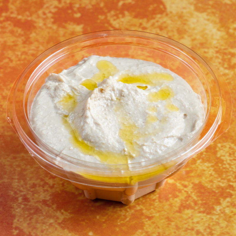 Bowl of creamy hummus topped with olive oil and spices