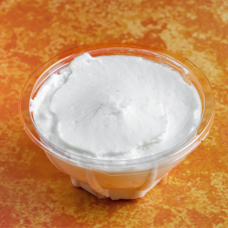 Large container of thick garlic sauce with spoon
